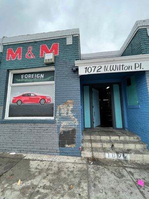 When the garage doors are open you can see  from the sidewalk the Inside of the M & M Auto Center on the garage wall the Grease Wall Mural