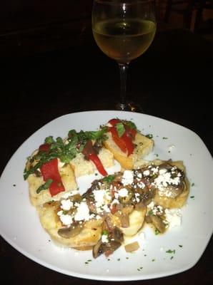 Bruschetta with mushrooms and feta on one side and mozzarella, basil and peppers on the other side on crusty Italian bread .