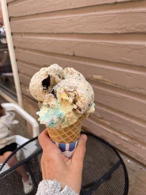 One scoop waffle cone with cookies and cream and birthday cake split.