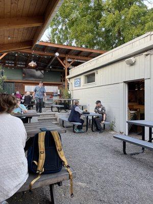 More outdoor patio with covered seating wraps around the back and a TV