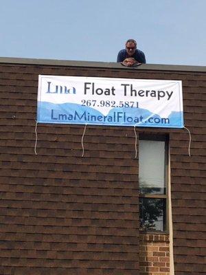 Owner, Keith, hanging the Lma banner at opening