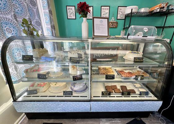 Display case of cakes, bars, brownies, and fudges