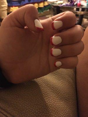 An acrylic set with white gel polish and a red French tip