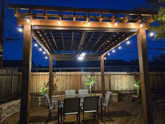 Deck, pergola, and surrounding wall at night