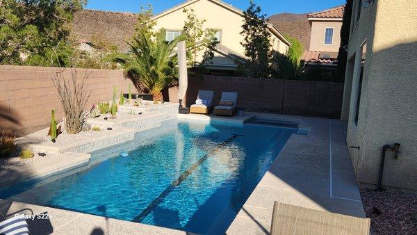 Small backyard pool/spa with swim lane tile. The raised planters house sheers. The desertscape accents the colors of the pool finishes.