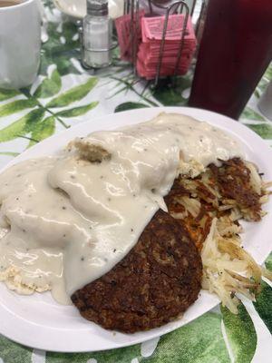 Biscuits and gravy with a sausage patty and hashbrowns