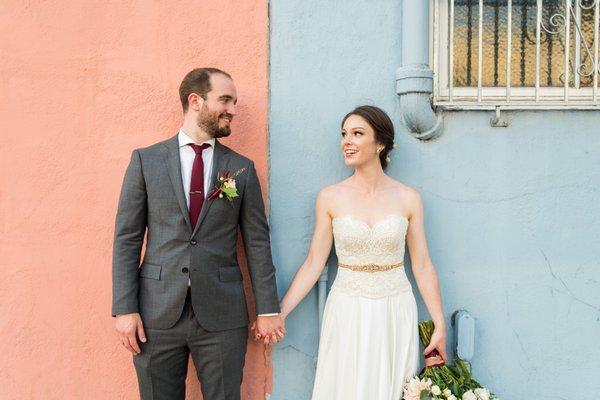 Portrait of Bride and groom in front of pink and blue wall