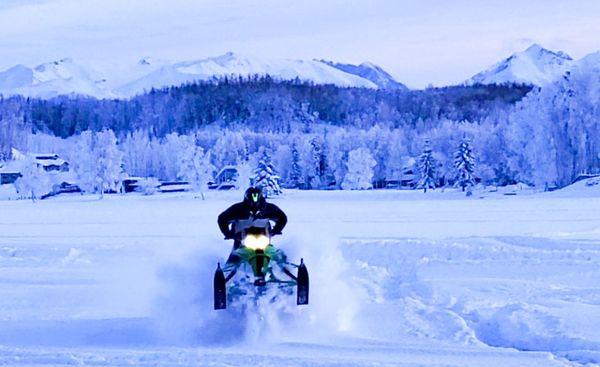 A rider "wheelies" his snowmachine (snowmobile, for the flatlanders) on a snowmachine tour