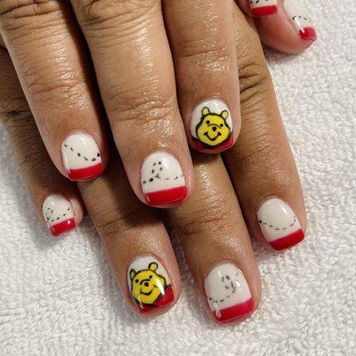 White DIP set with red tips and Pooh Bear inspired nail art.