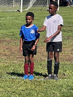 Big cousin instructing little cousin & coach telling him to listen.