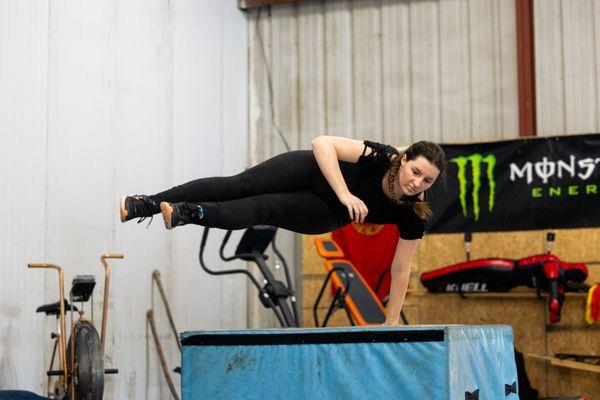 Photo of Ema Tibbetts learning how to speed vault over obstacles.