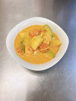 A combination of shrimp and chicken with avocado, potatoes, carrots, bell peppers, and basil leaves in a special curry paste.