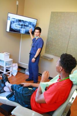 Dr. Kang explaining the results of a CT scan to a patient