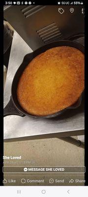 Baked golden  honey sweet  cornbread  in an iron skillet  with a drizzle of honey