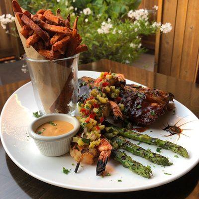 Half rack of ribs with a skewer of grilled shrimp topped with pineapple relish, served with sweet potato fries. #hapybistro #hapyspecials