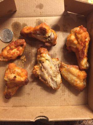 Sad excuse for wings. The quarter is for scale. And No I did not take a bite out of the center one, it came that way.