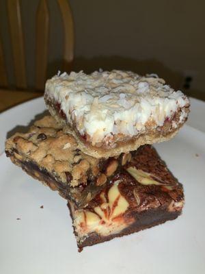 Coconut cherry bar on top, PB&J bar below, red velvet cheesecake brownie bar on bottom.