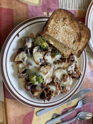 Home fries topped with broccoli, carrots, mushrooms, cheddar; sourdough toast