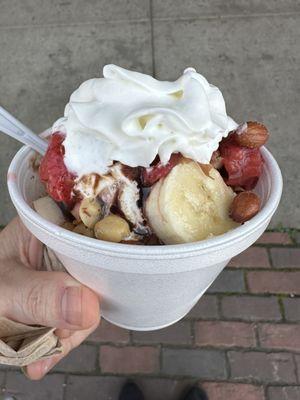 Sundae with bananas, strawberries, chocolate, nuts and whip cream