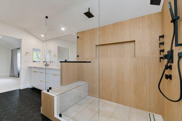 Elegant bathroom featuring a spa-like walk-in shower, dual vanity with marble countertops, modern fixtures, and stylish hexagonal flooring.