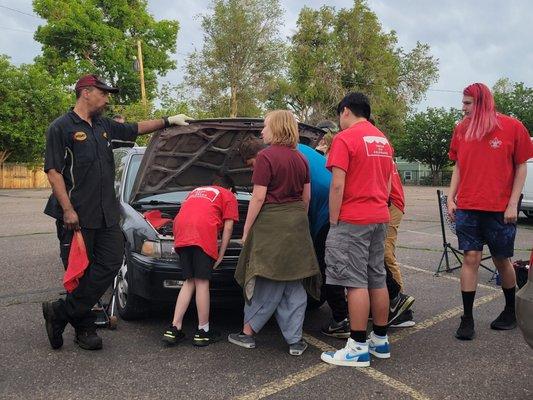 Scott from Midas giving Scouts a hands-on opportunity in automotive maintenance.