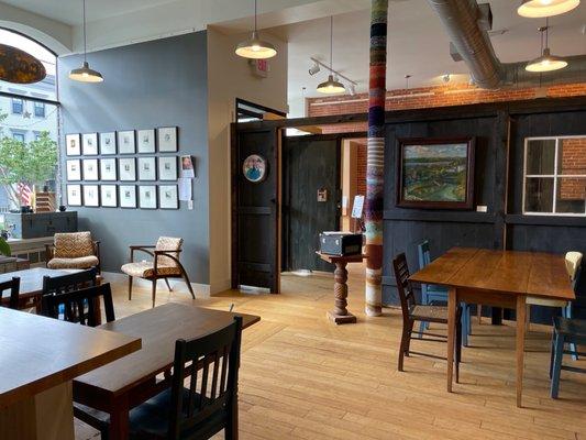 Funky seating area with local art on the walls, original wood floor.