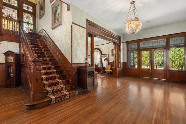 Elegant staircase filtering sunlight through stained glass.