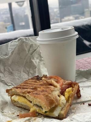 Breakfast sandwich with bacon, tomatoes and American cheese... plus some coffee