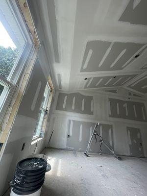 Another bedroom with drywall installation and 3 coats of joint compound drying stage.