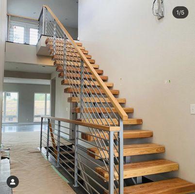 Custom built single spine staircase with red oak treads, and horizontal railings with red oak wood cap