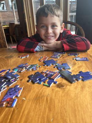 Logan playing building puzzle in the "living room"