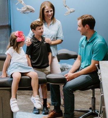 Dr. Denson speaking with a young family about healthy smiles.