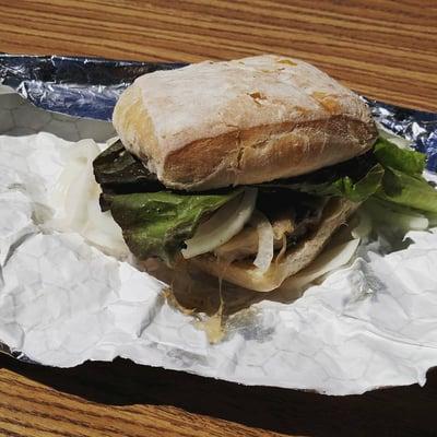 Beef burger with Swiss cheese, lettuce, tomato and lots of onion on ciabatta bread. Yum!