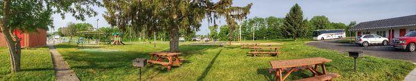 Panorama of playground, volleyball, picnic tables, and a few grills