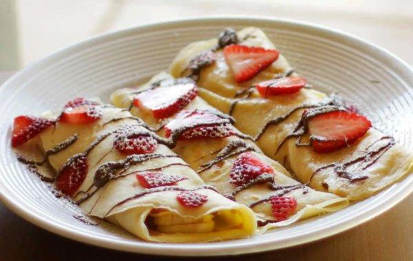 Fluffy crepe with a warm chocolate drizzle topped with fresh strawberries