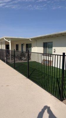 Finished product with rod iron fence and synthetic grass off of patio