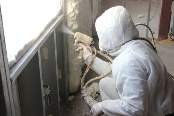 Foam Engineers applies open cell spray foam insulation in a metal stud cavity to insulate an exterior wall in this commercial building.