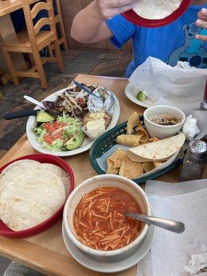 Angel hair soup.  Nachos.  Jarrones steak with baked potato and frijoles and avocados.