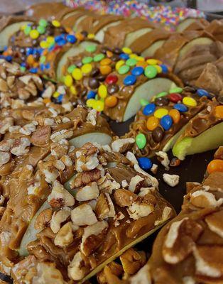 Sliced caramel apples. 
Pecan, M&M's, Plain, and  Sprinkle caramel apples.