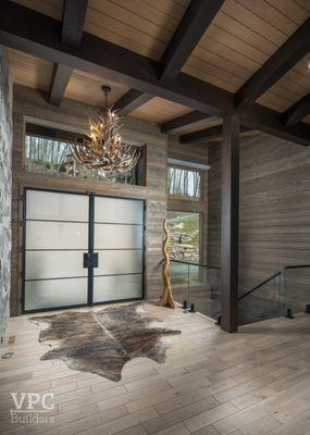 Step into luxury with a custom built entryway and stunning antler chandelier