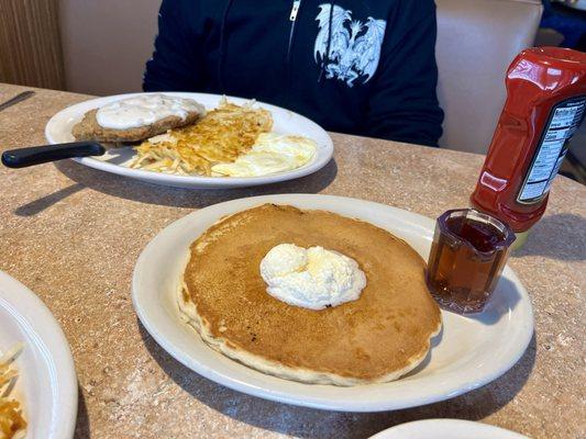 Chicken fried steak and eggs and a pancake