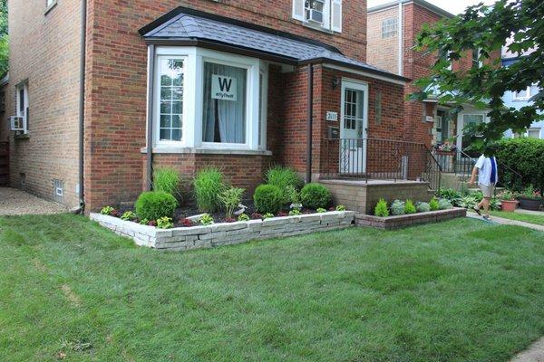 After Landscaping:
 Objective: New sod installed, Natural cut stone flower bed installed among new plants for a new summer season.