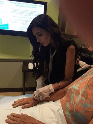 Dr. Mira Mahajan injecting Radiesse into the hands of a patient.