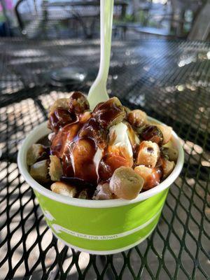 Small cup of vanilla soft serve with cookie dough and chocolate syrup.