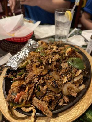 Shareable fajita platter, which comes loaded with warm tortillas, chorizo, beef, chicken, shrimp, peppers, and onions!