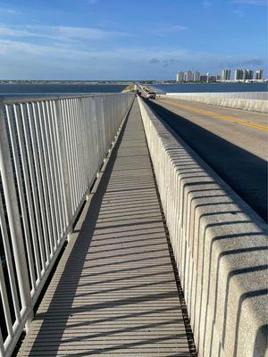 Running down the causeway pedestrian path toward the beach