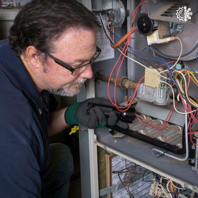 tech on a furnace repair service call inspecting unit