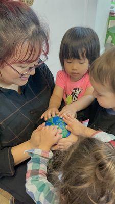 A teacher is showing younger students a squash and soft earth form