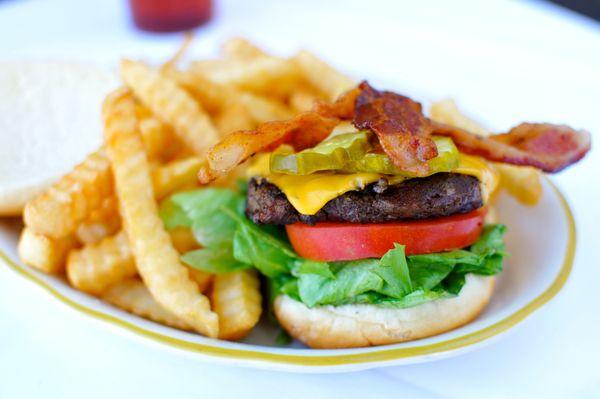 A tasty cheeseburger with crisp bacon strips, fresh lettuce, sliced tomato and mayo. Try it with barbecue sauce for that Western touch.