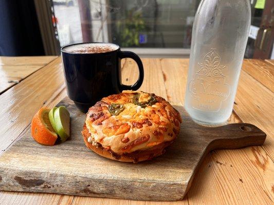 Egg and cheese bagel with pickled onions on a jalapeño cheddar bagel